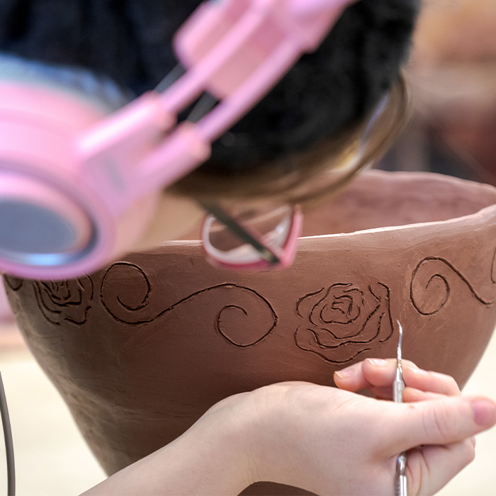 A student working on a pottery piece.